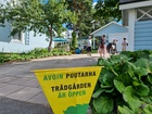 Keltainen kyltti kertoo, että puutarha on avoinna teemapäivänä kaikille kiinnostuneille.